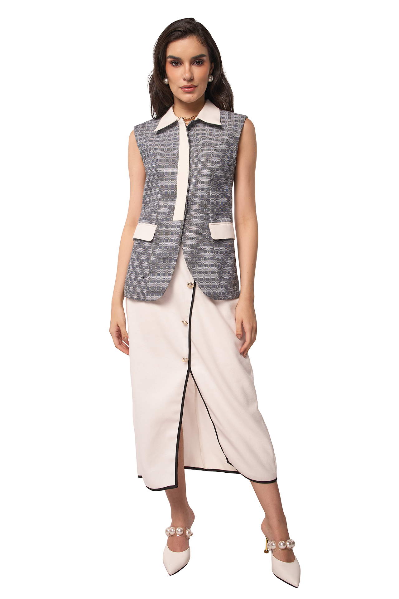 Woman wearing a sleeveless patterned vest over a white top and pants on a white background