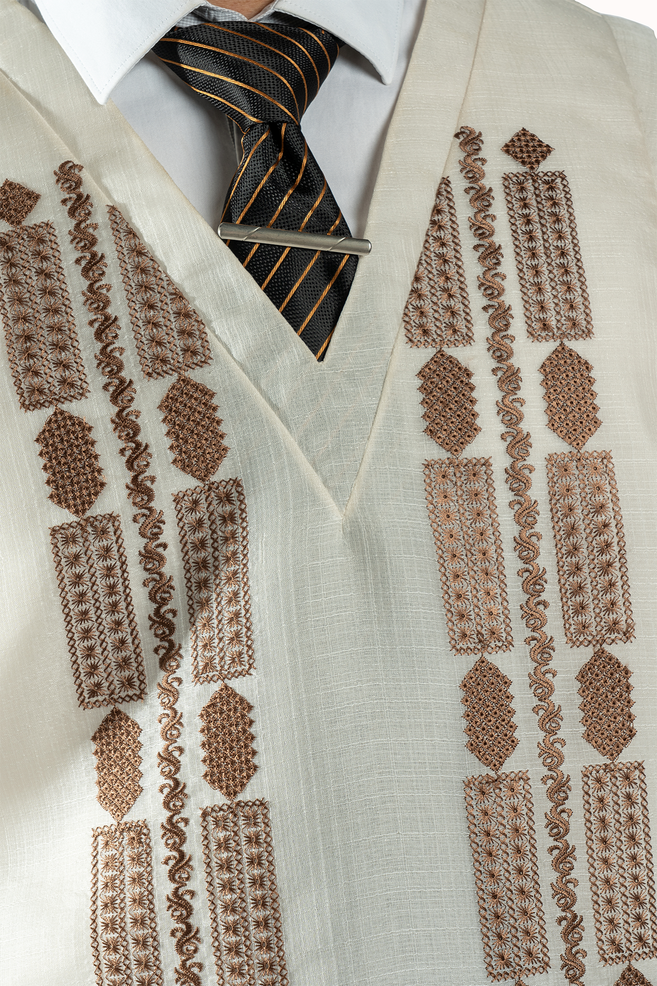 Close-up of a patterned vest with a striped tie underneath