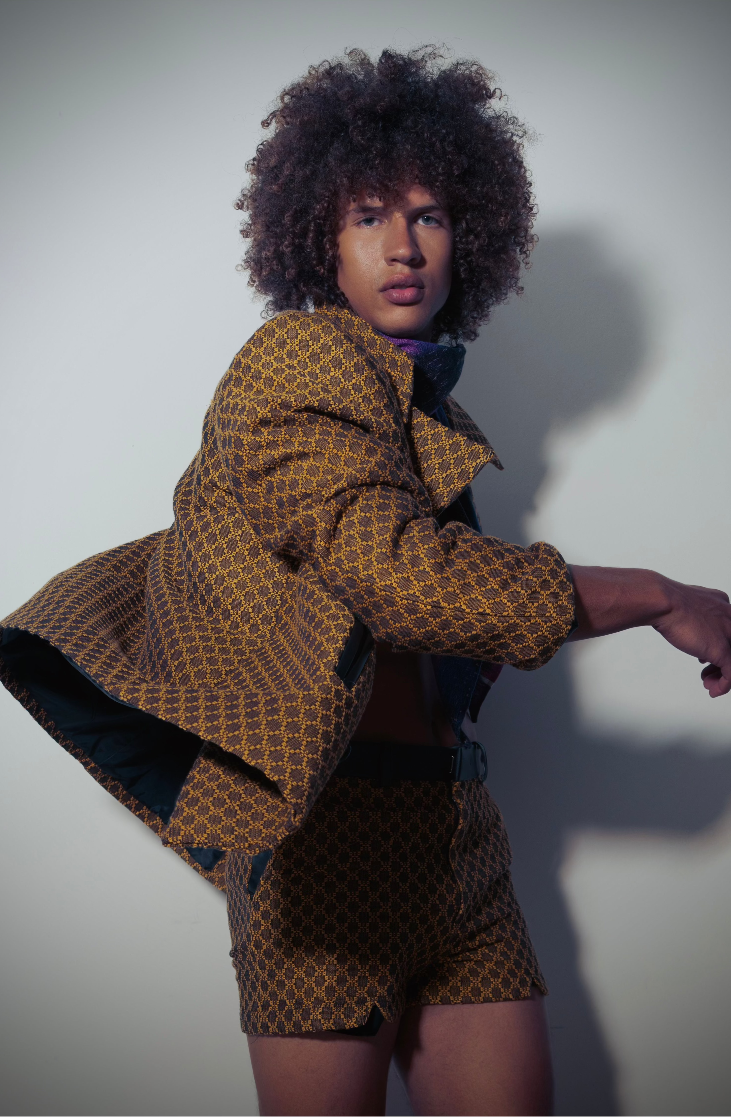 Person wearing a patterned outfit against a plain background